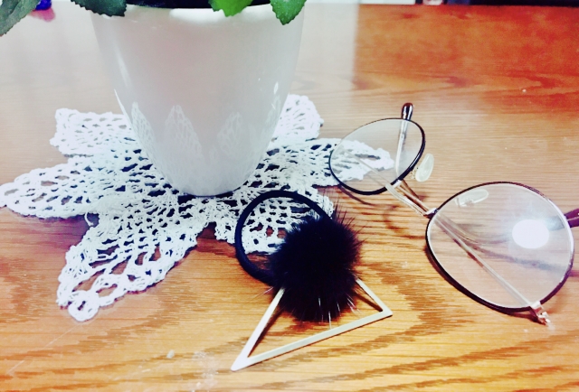 机の上にあるメガネをヘアゴム