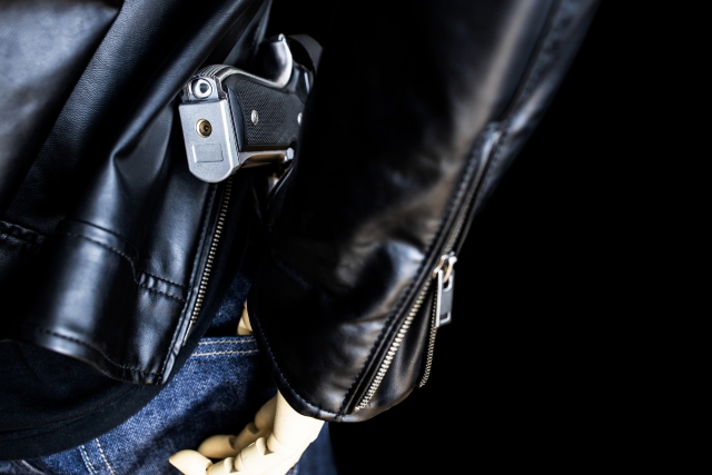 銃を持つ革ジャンの男性
