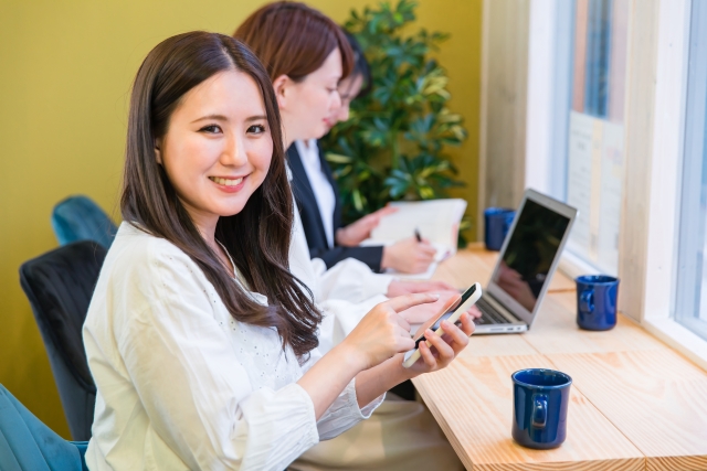 女性二人でパソコンをいじる女性