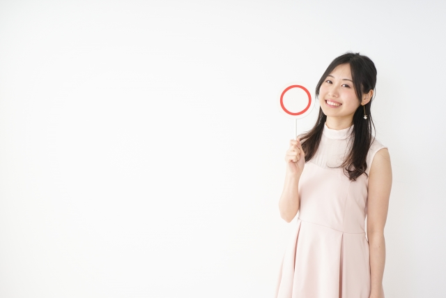 丸の札をもっている女性